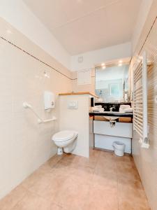 a bathroom with a toilet and a sink at Tulip Inn Honfleur Residence & Spa in Honfleur