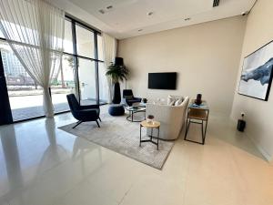 a living room with a couch and chairs and a tv at Marassi Beach Residence Bahrain in Rayyā