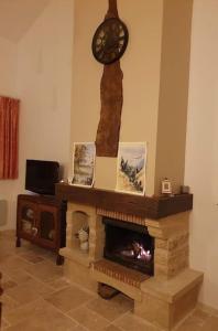 a living room with a fireplace with a clock on the wall at Gite spacieux - 3 chambres - Calme et charmant in Cubnezais