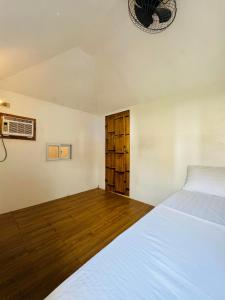 a bedroom with a white bed and wooden floors at Villa Del Cascel in Bulala +24 photos