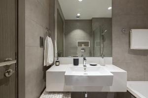 un bagno con un lavandino bianco e uno specchio di Crystal Lagoon View Beach access Fast Wi-Fi a Dubai