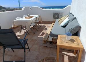 a balcony with a bed and a table and chairs at Casa adosada Rompeolas-Atlanterra in Zahara de los Atunes