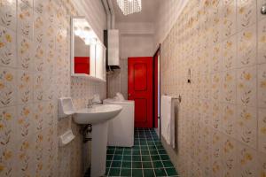 a bathroom with a white sink and a red door at Casa Vista Mare e Parcheggio in Marotta +13 photos
