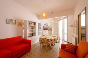 a living room with a red couch and a table at Casa Vista Mare e Parcheggio in Marotta