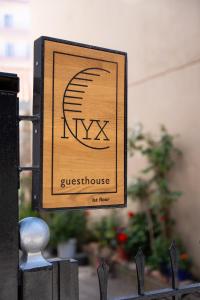 a sign on a fence with theigil at NYX Guesthouse in Tripolis