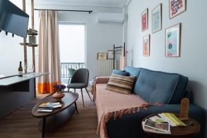 a living room with a blue couch and a table at NYX Guesthouse in Tripoli