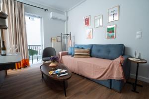a living room with a blue couch and a table at NYX Guesthouse in Tripoli