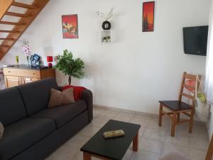 a living room with a couch and a table at Villa climatisée 4-6 pers avec piscine, terrasse & jardin - 2 min plage in Cervione