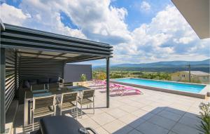 eine Terrasse mit Tisch und Stühlen und ein Swimmingpool in der Unterkunft Beautiful Home In Glavina Donja in Donja Glavina