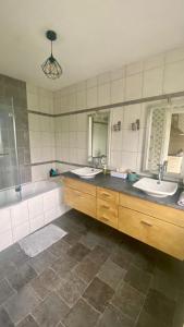 a bathroom with two sinks and a tub and two mirrors at Les Perdrix in Charleville-Mézières +18 photos