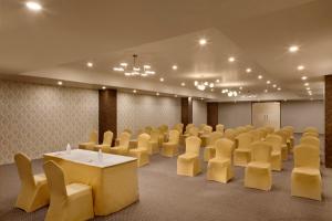 斋浦尔Click Hotel Jaipur, Raja Park的一间房间,里面摆放着一排椅子和一张桌子