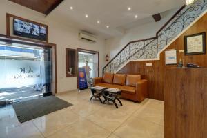 a living room with a couch and a staircase at Hotel A. K. International - Fort in Mumbai