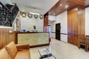 a man standing at a counter in a lobby at Hotel A. K. International - Fort in Mumbai