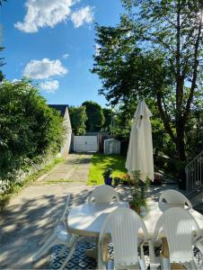 a patio with a white table and chairs and an umbrella at Les Perdrix in Charleville-Mézières