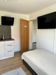 a bedroom with a bed and a tv on the wall at Deluxe Studio Bella in Backnang