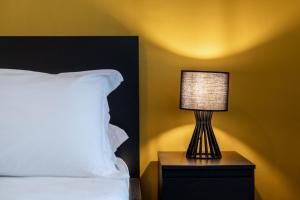 a lamp sitting on a night stand next to a bed at I Remi Del Prione by Le 5 Terre La Spezia in La Spezia