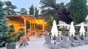 a patio with chairs and tables and umbrellas at Santa Marina Holiday Village - Purple Harmony Sea view in Sozopol