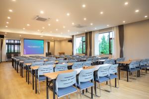 une salle de conférence avec des tables, des chaises et un écran dans l'établissement A Mountain Home别有洞天-山居民宿, à Taiping 37 autres photos