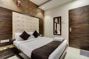 a bedroom with a large bed with a large headboard at Hotel A. K. International - Fort in Mumbai