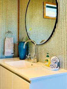a bathroom with a sink and a mirror at GORGE Chocolates Tiny House in Kennedys Creek +19 photos