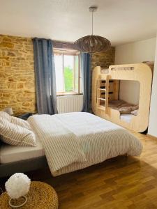 ein Schlafzimmer mit Etagenbett und Fenster in der Unterkunft La Maison Cosy in Frontenay