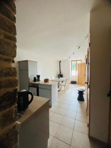 eine Küche mit weißen Geräten und einem Tisch in einem Zimmer in der Unterkunft La Maison Cosy in Frontenay