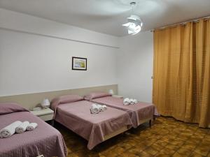 a bedroom with two beds with hello kitty towels on them at Hotel Fernanda in Letojanni