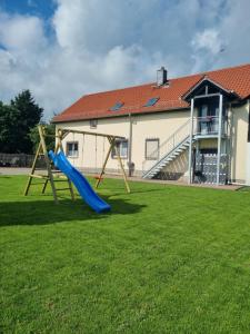 ein Spielplatz mit Rutsche im Hof in der Unterkunft Ferienwohnung Harzliebe - am Fuße des Brocken in Wernigerode