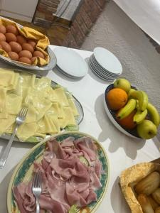a table topped with plates of food and bowls of fruit at Hotel Fernanda in Letojanni