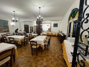 a restaurant with tables and chairs and people sitting at them at Hotel Fernanda in Letojanni