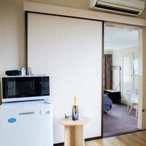 a living room with a microwave and a table at Chic Private Studio 5 mins from Airport and shops in Christchurch +22 photos