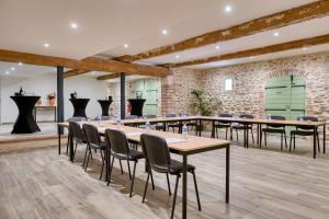 a room with tables and chairs and a brick wall at CHATEAU LAURIGA in Thuir