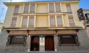 ein großes Gebäude mit zwei Türen und Fenstern in der Unterkunft Hostal Joaquín in Ventas con Peña Aguilera
