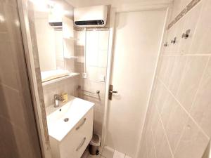 Un baño blanco con lavabo y ducha. en Le TIKAL studio 4 pers, centre-ville port, clim, en La Grande-Motte 18 fotos más