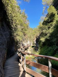 una pasarela de madera sobre un río con un puente en Olivae apartamento, en La Iruela 5 fotos más
