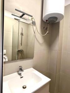 a bathroom with a sink and a mirror at Coastal Comfort Apartament in Golem