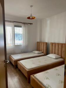 a bedroom with two beds and a window at Coastal Comfort Apartament in Golem +9 photos