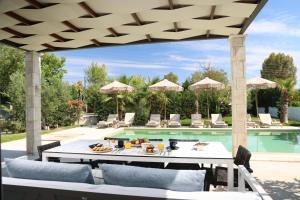 a patio with a table and chairs next to a pool at W Villas Halkidiki in Pefkochori +18 photos