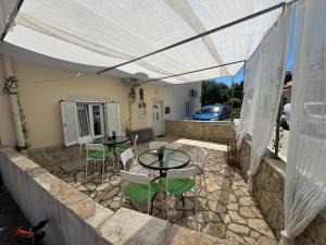 a patio with two tables and chairs under a tent at Apartmani Luciano in Novalja