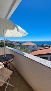a patio with a table and an umbrella on a balcony at Apartments Mare in Ulcinj