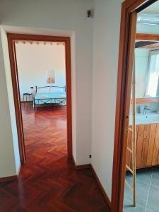 un corridoio con una camera con letto e specchio di B&B Nel Vigneto a Castelplanio