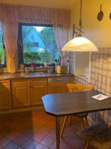 een keuken met een tafel, een wastafel en een raam bij Entire home close to Hamburg, train&airport nearby in Norderstedt