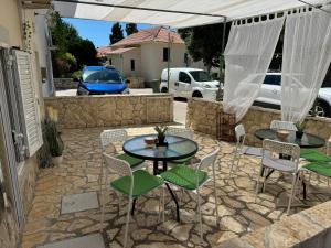 a patio with two tables and chairs on a stone patio at Apartmani Luciano in Novalja