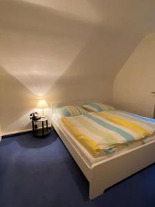 een slaapkamer met een bed en een tafel met een lamp bij Entire home close to Hamburg, train&airport nearby in Norderstedt