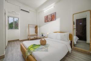 顺化KLy Apartment Hotel的卧室里有一张白色的大床和一面镜子