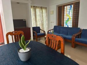 a living room with a table and a blue couch at Halcyon Homes-Trivandrum in Chacka