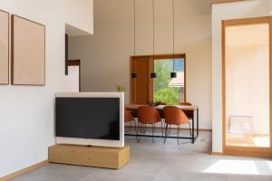 a living room with a tv and a table with chairs at Panorama Chalet in Bayrischzell +27 photos