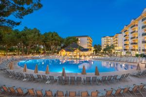 een groot zwembad met stoelen en parasols bij Can Picafort Palace in Can Picafort +63 foto's