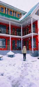 索纳马格Mitra Sonamarg的建筑物前在雪中行走的人