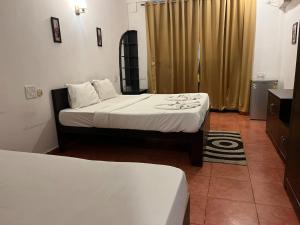 Hotel pleasure inn near turtle beach morjim Manage by ld group of hospitality客房内的一张或多张床位